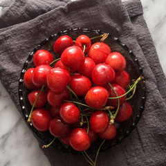 Fresh sweet cherries bowl with water drops on the table