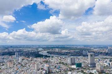 Naklejka premium Widok z góry budynku w mieście - widok z lotu ptaka Wieżowce latające dronem Ho Chi Mi City z budynkami deweloperskimi, transportem, infrastrukturą energetyczną. obejmują Landmark 81 i błękitne niebo,