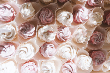 White and pink meringue in candy bar. Top view in sunlight.