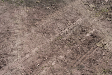 Texture of gray earth with car tire prints