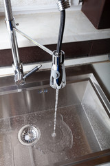 Flow of water in a metal sink on a modern kitchen - 272595806