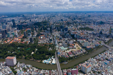 Naklejka premium Top View of Building in a City - Aerial view Skyscrapers flying by drone of Ho Chi Mi City with development buildings, transportation, energy power infrastructure. include Landmark 81 and blue sky ,