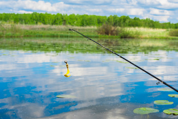 Fishing hook and rubber boat. Pitchers in the lake, meadow and forest. Outdoor activities not in nature