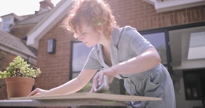 Young Adult woman doing carpentry DIY on patio