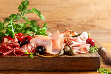 Assorti of sliced jamon, salami, ham with olives ,capers, pickles and stuffed red peppers