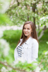 Beautiful girl blowing. portrait of a girl in a blooming apple tree.