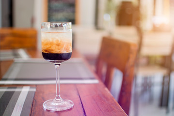 A glass of Black Russian alcoholic cocktail, liquor menu cool drink on the wooden table in the restaurant