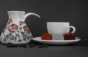 A cup of Turkish coffee with marmalade marbles on gray background