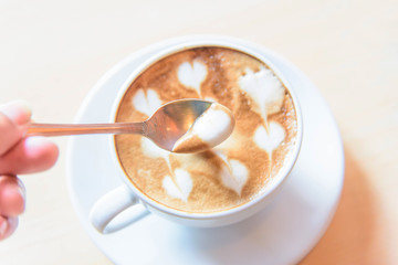 lap milk foam of coffee by spoon