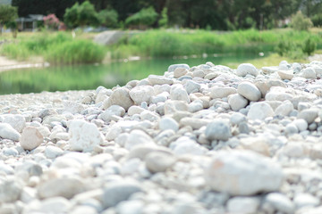 Stone, lake and green grass background. Spring and summer