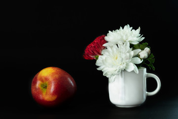 red white flower in white ceramic mug and apple fruit for food rococo classic still life style on black background