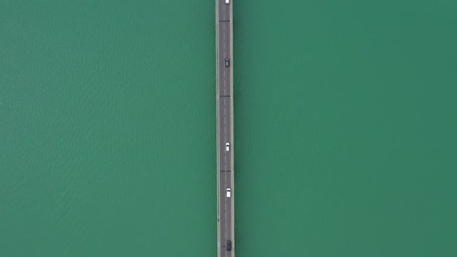 Perfect symmetric aerial drone shot over a bridge lake Saint Cassien France cars and traffic