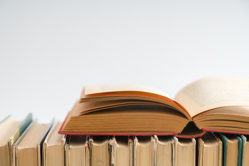 Naklejka premium Open book on white background, hardback books on wooden table. E