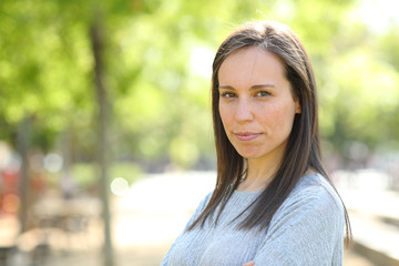 Confident woman looking at camera outdoors in a park