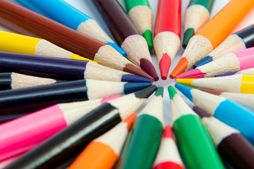 Naklejka premium An assortment of colour pencils in circle, spiral on white backg