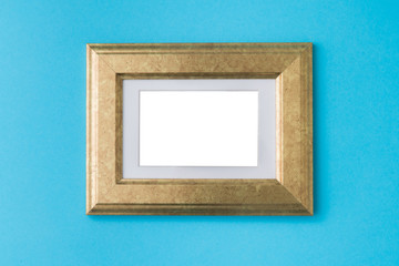 Blank empty golden frame on blue background. Art gallery, museum