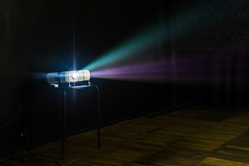Close-up of multimedia projector with colourful rays of light pr