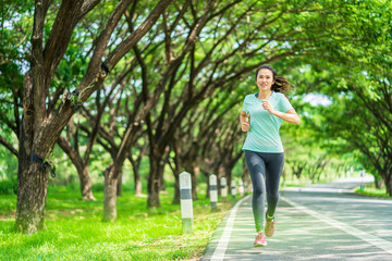 Young asian woman running on road in the nature.