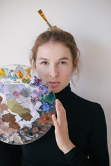 Fototapeta premium Woman painter with palette of paint in her hands