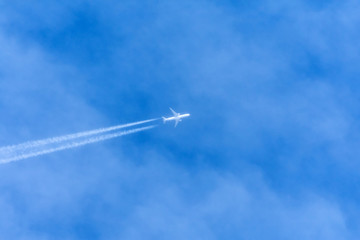 Contrail in the sky higher than clouds left by commercial liner.