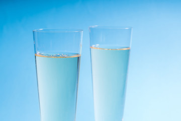 Close up of two glasses of champagne isolated on a blue backgrou