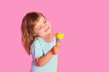Child girl eating ice cream  in waffles cone  on pink background.