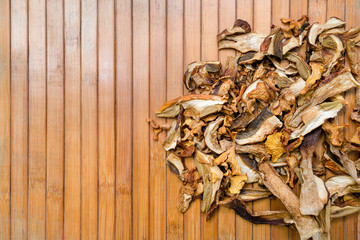 Top view of dried mushrooms on wooden background with space for