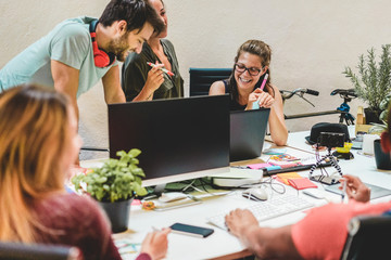 Young co-workers team talking during startup - Happy people planning a new project in creative...