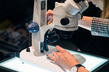 young female scientist looking through a microscope in a laboratory
