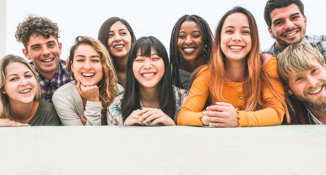 Happy millennial friends from diverse cultures and races having fun posing in front of smartphone camera - Youth and friendship concept - Young multiracial people smiling - Main focus on center faces