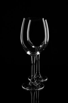 Two empty transparent wine glasses, isolated on black background