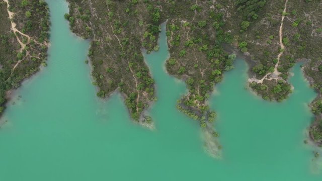 Close to high aerial shot of the lake saint cassien shore with trees and path France var 