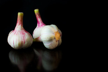 Garlic bulbs, on black background.Copy space	