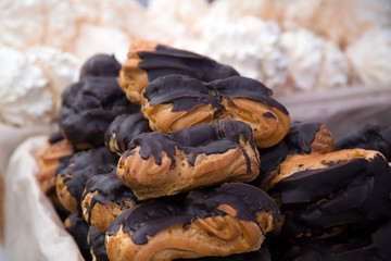 Bunch of ecler pastry covered with chocolate stacked on top of each other at the food market