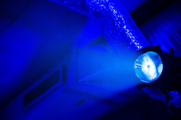 Bright blue light at the underground parking garage with ventilation pipes at background