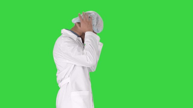 Arabic doctor walking and putting medical cap on on a Green Screen, Chroma Key.