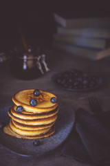 American Pancakes with Organic Berries and Maple Syrup on Dark Background. Classic Homemade Breakfast.