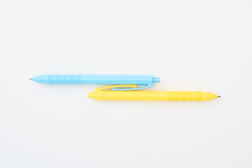 top view of yellow and blue pencils on white background