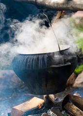Big black cooking pot on fire outdoors