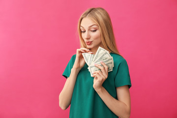 Young woman counting money on color background