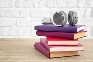 Fototapeta na wymiar Books and modern headphones on table. Concept of audiobook
