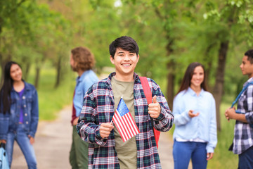 Asian student with USA flag outdoors