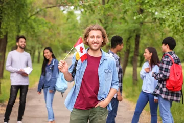 Papier Peint photo autocollant Canada Young student with Canadian flag outdoors