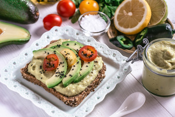 Organic Guacamole Avocado Spread and Slices with Fresh Cherry Tomato and Black Sesame. Healthy Diet Breakfast Concept.