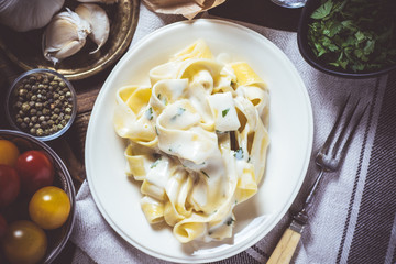 Traditional Italian Alfredo Pasta Plate with Creamy Cheese and Basil Sauce