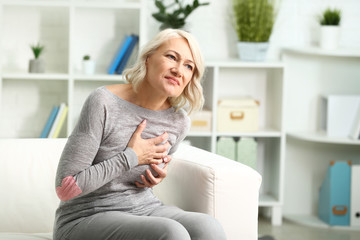 Mature woman suffering from heart attack at home