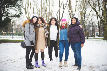 group of young women posing for picture in park with cover snow