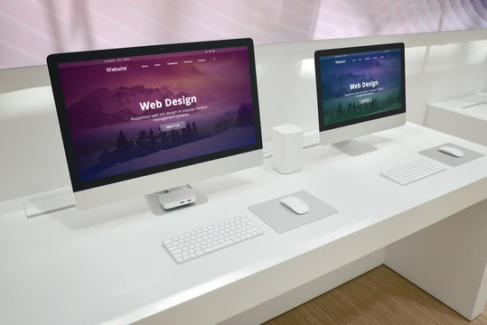 Web design development studio with two monitors and web site presentations.