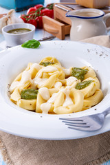 Tortellini di formaggio with basil pesto and cheese sauce