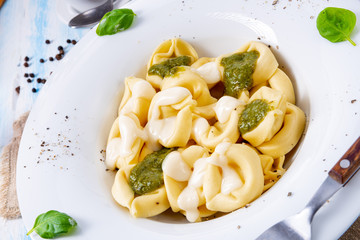 Tortellini di formaggio with basil pesto and cheese sauce